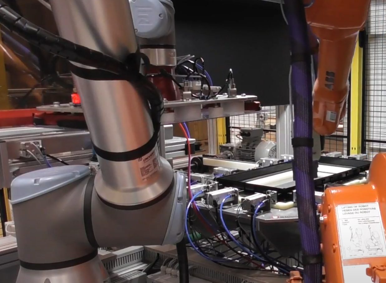 Two robots handling the gluing process in the cell