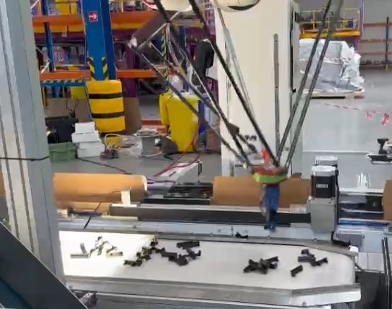 Delta-robot loading station picking parts from the conveyor